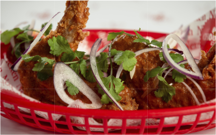 Fried chicken tenders topped with sliced onions and coriander from Chooks Fried Chicken, Edinburgh